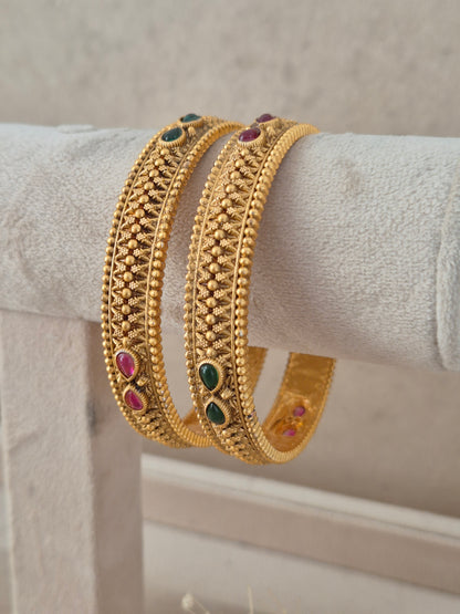  of 2 – traditional gold-plated ethnic bangles with textured mesh pattern and red-green gemstone accents by Naitri.in