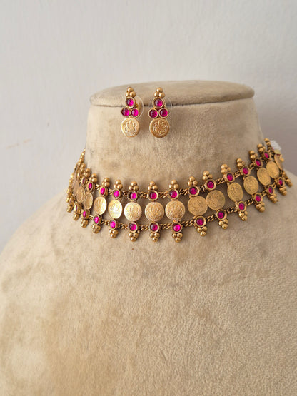 Modern Indian imitation jewelry set featuring an intricate golden brass alloy coin choker necklace with ruby-red gemstone accents, by naitri.in