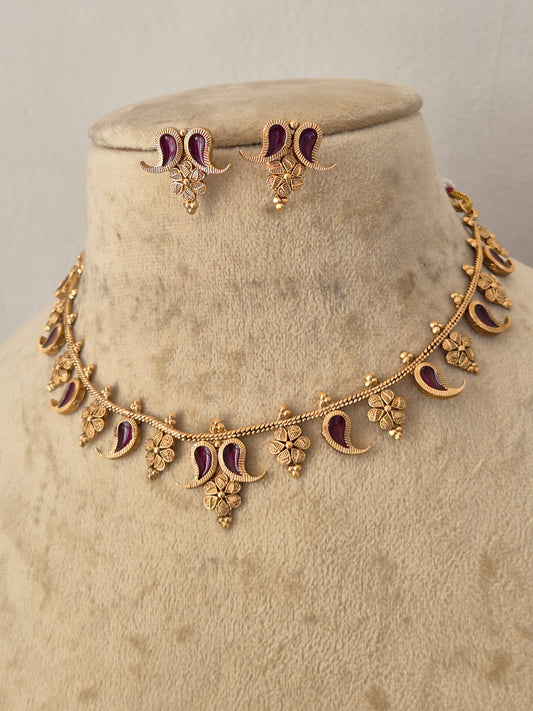 Gold-toned traditional Indian jewelry set featuring a floral garland necklace and matching earrings, embellished with deep wine enamel details, by naitri.in