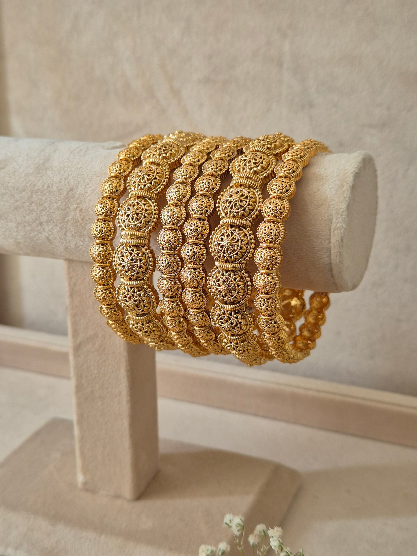 Close-up of Naitri Sona premium gold-plated bangle set featuring traditional Indian ethnic engraving and geometric patterns by naitri.in