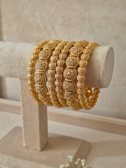 Close-up of Naitri Sona premium gold-plated bangle set featuring traditional Indian ethnic engraving and geometric patterns by naitri.in
