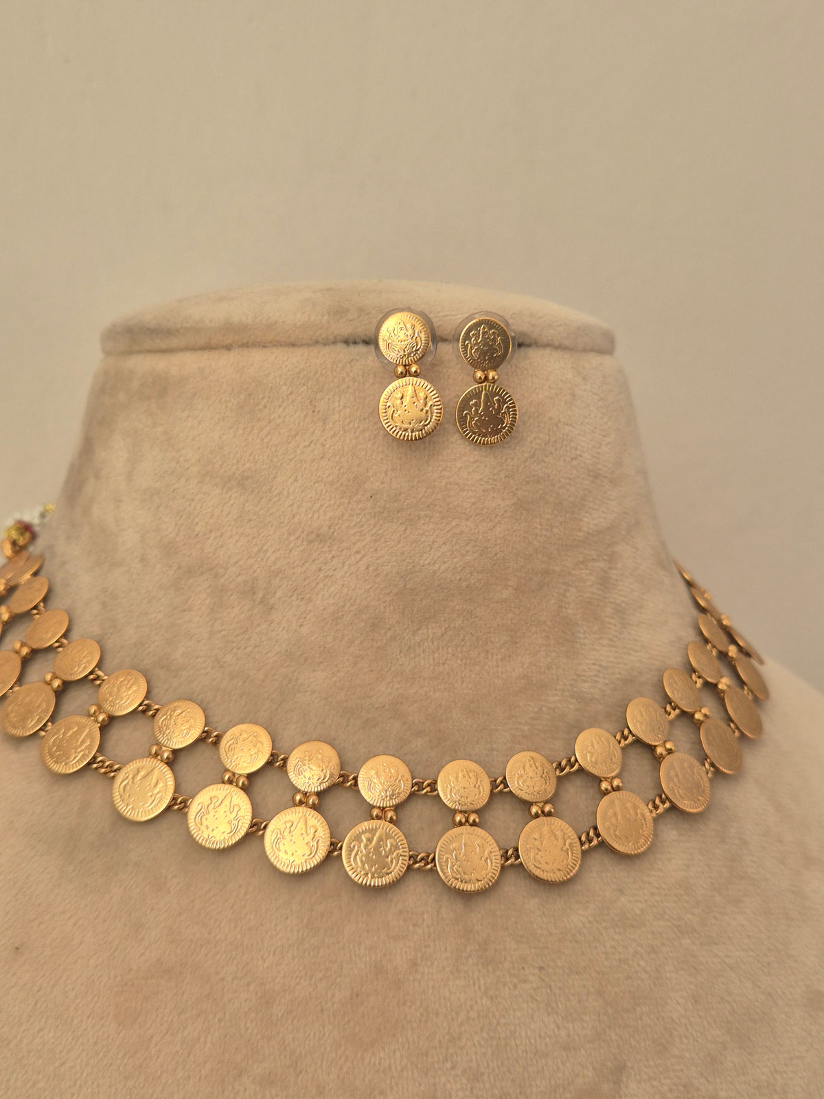 Gold coin-style choker necklace with matching circular stud earrings by naitri.in
