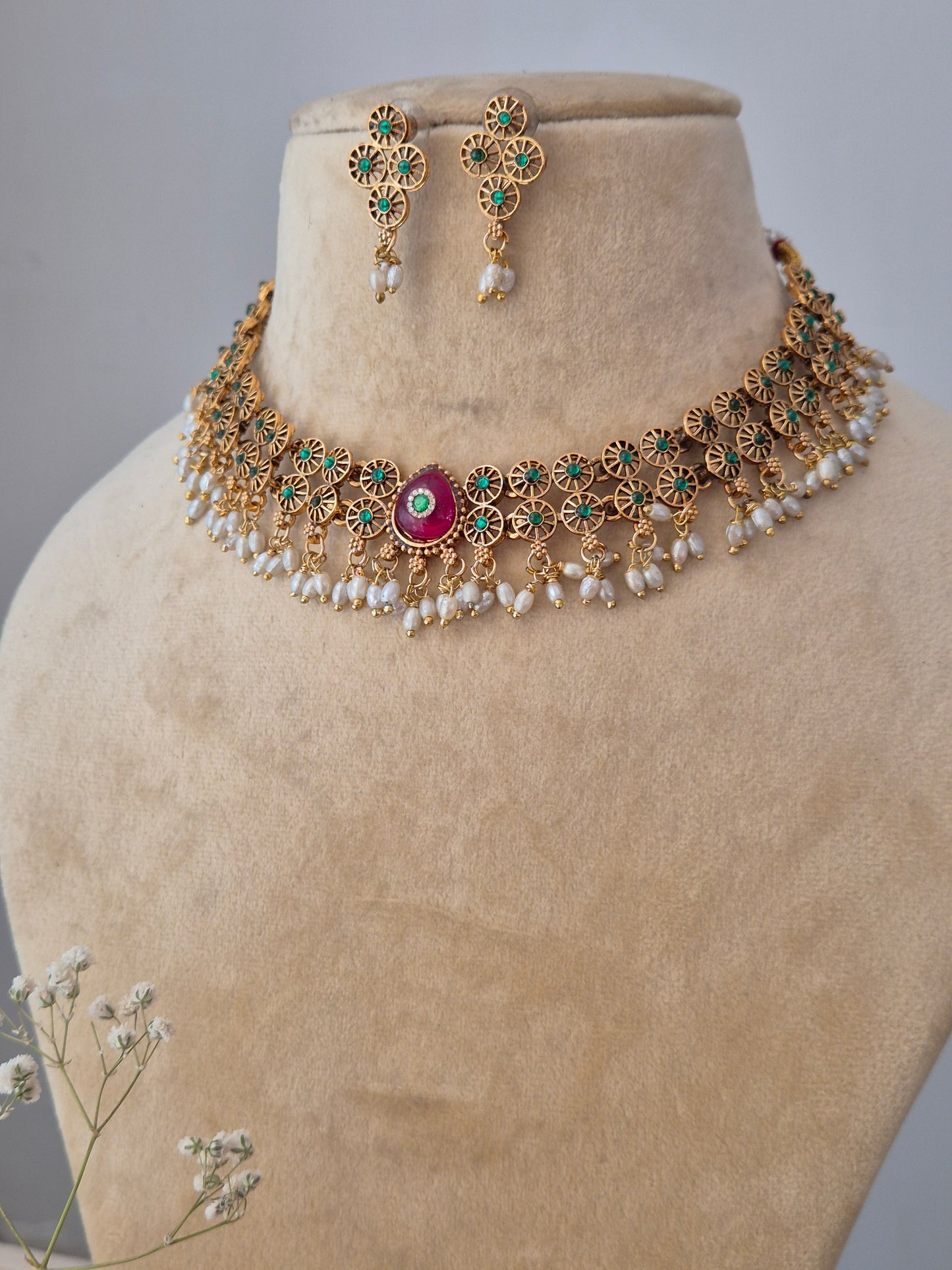 Modern Indian Tashvi necklace set in antique gold with red stone details, Handcrafted  gold beads, red stones, and a polished brass finish by naitri.in