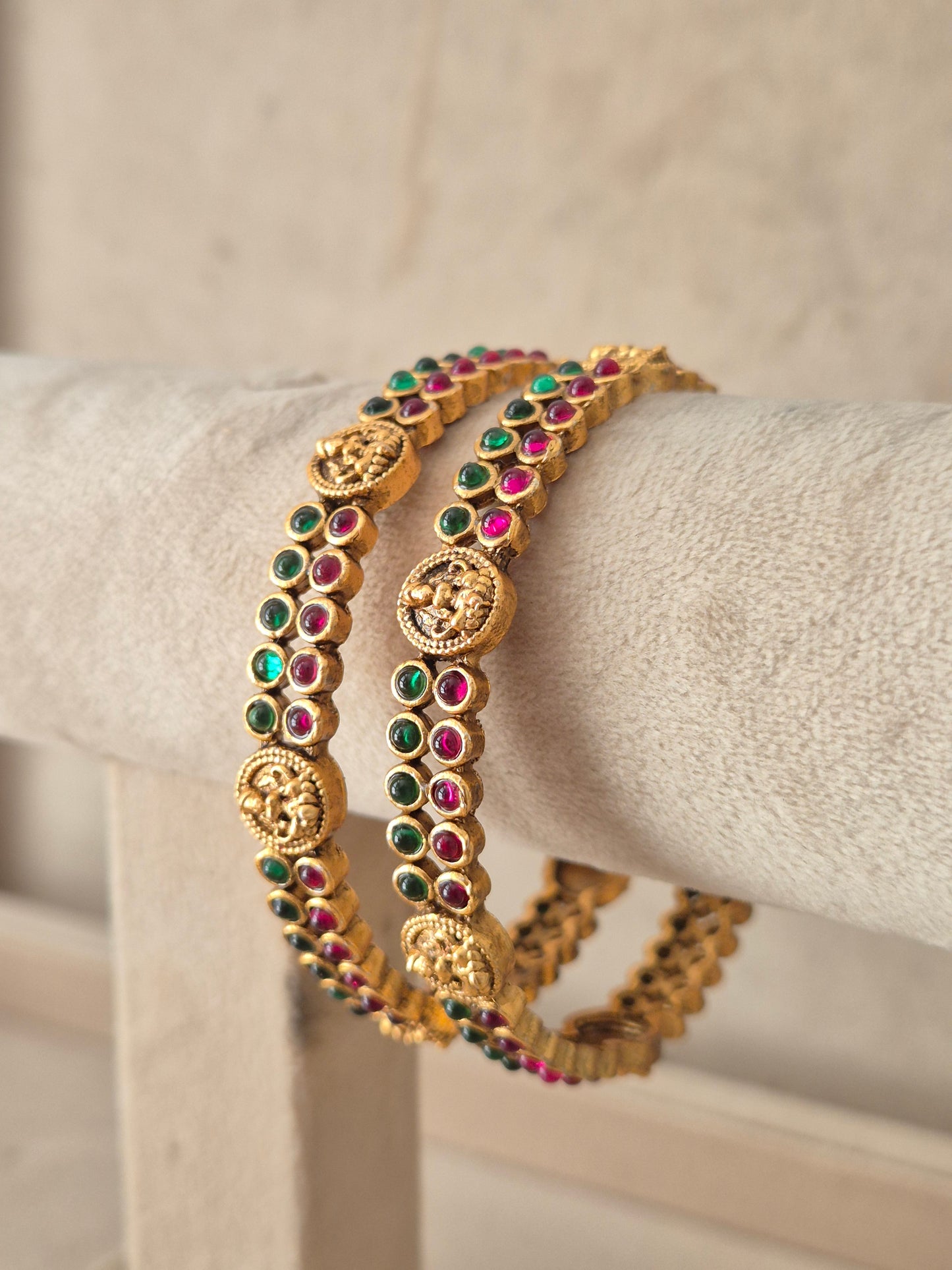 set of 2 antique gold-plated bangles decorated with circular coin motifs and red and green stone by naitri.in