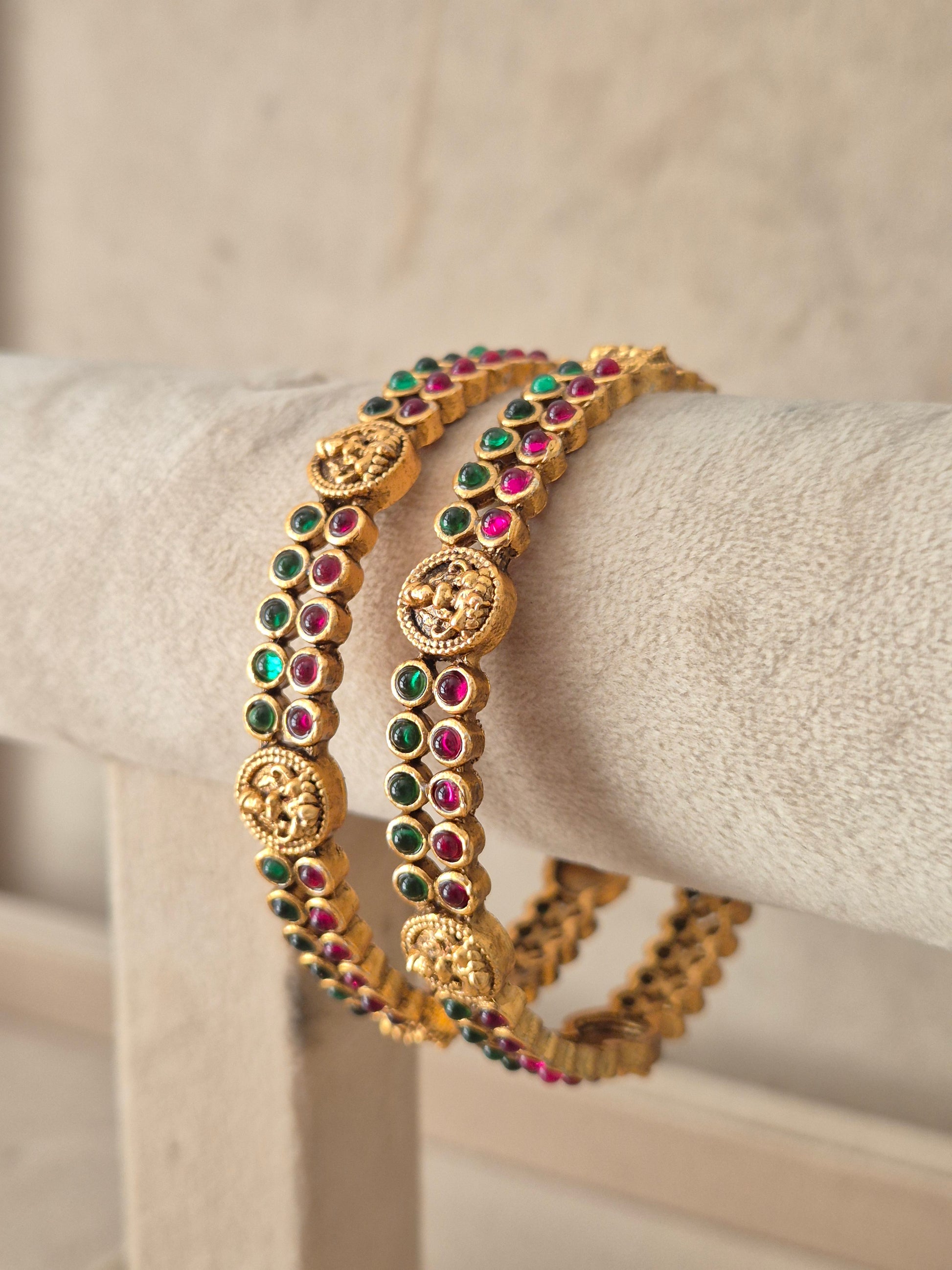 set of 2 antique gold-plated bangles decorated with circular coin motifs and red and green stone by naitri.in