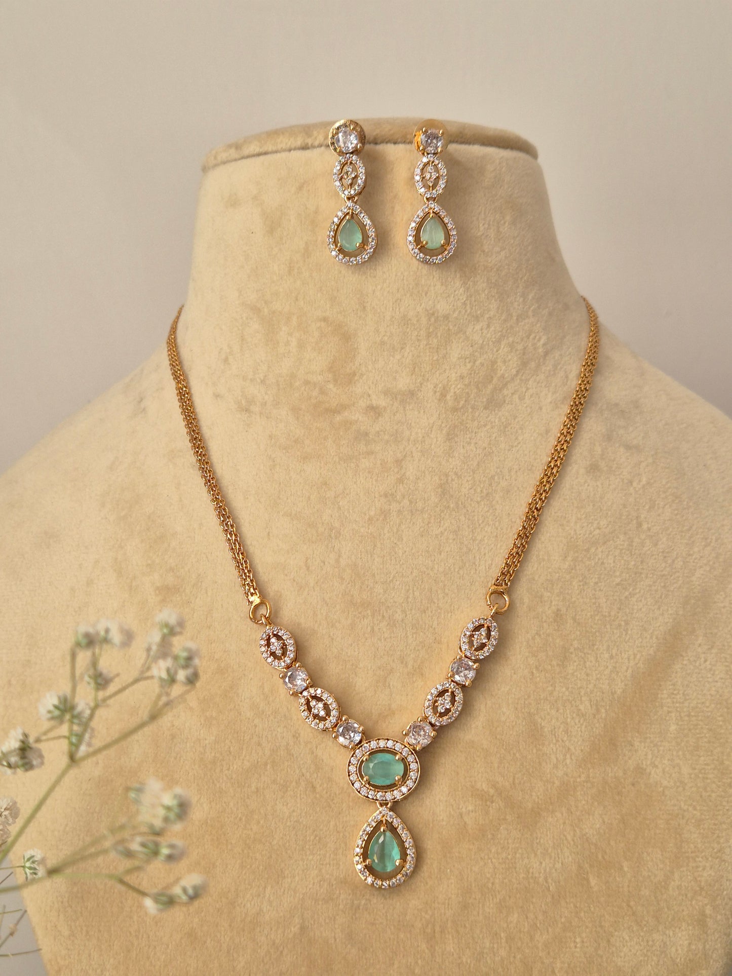 Delicate gold-plated jewelry set with pale green accents, ideal for modern ethnic styling and festive occasions by naitri.in