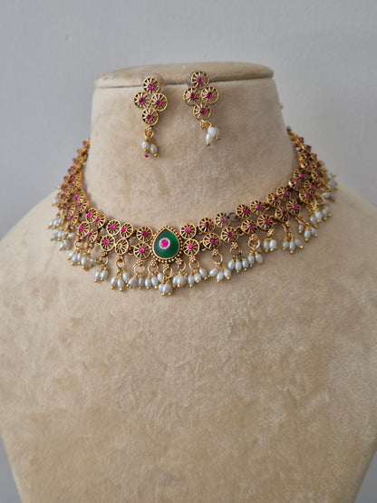 Traditional gold set with pink and green stones and pearl droplets, including matching stud earrings by naitri.in