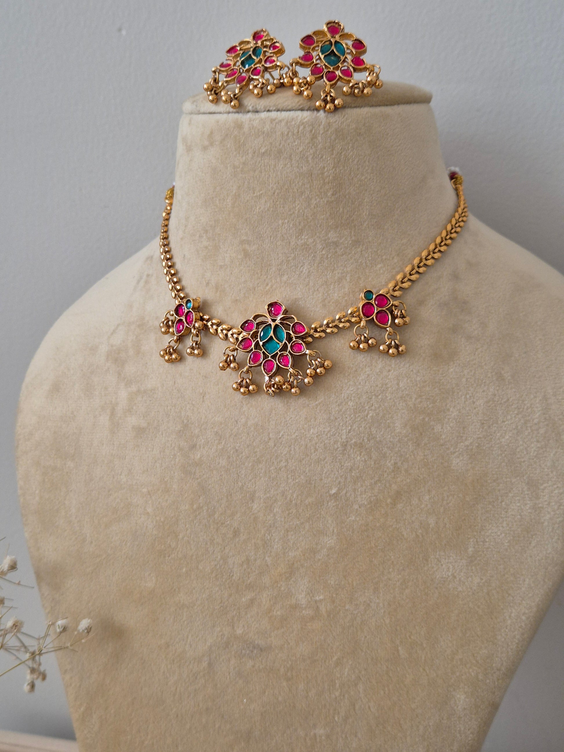 Gold-toned Yasmin necklace and earring set with red and green floral designs by naitri.in