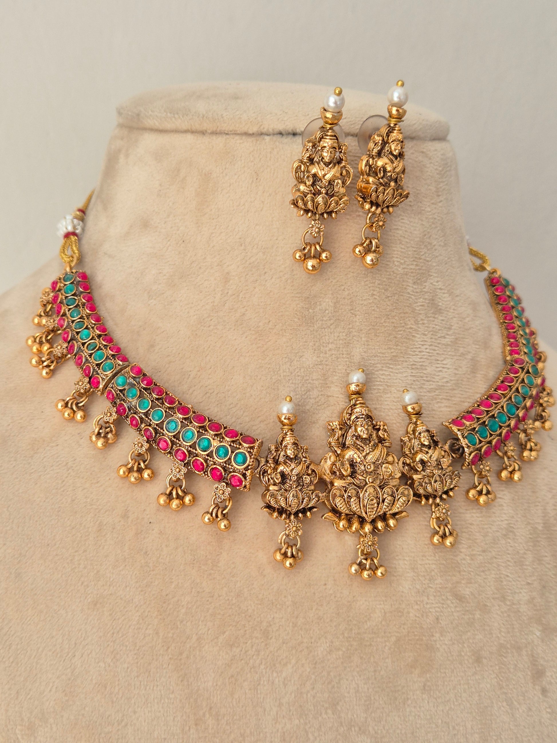 Gold-toned traditional Indian jewelry set featuring a choker necklace and matching earrings, embellished with turquoise and pink stones and small pearl-like accents, by naitri.in