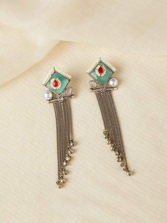 Green and blue stud earrings, Isharya by Naitri on plain display card.