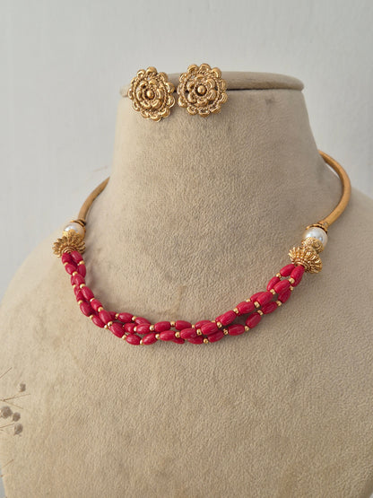 Traditional Indian Imitation Jewellery showing a detailed view of a vibrant red beaded necklace and small golden stud earrings designed for ethnic festive wear by Naitri.in