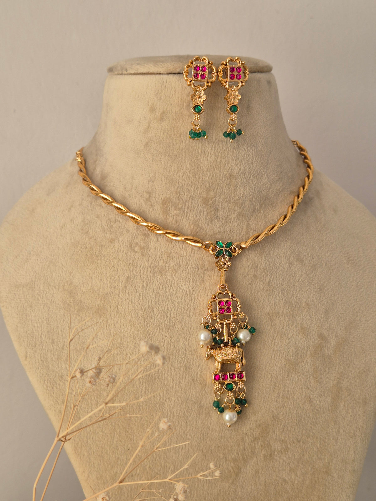 Ornate Designer Pendant Choker Set presented on a display bust, highlighting the classic Indian motif work, rich gold-toned texture, and delicate dangling elements ideal for festive and traditional occasions by Nairi.in