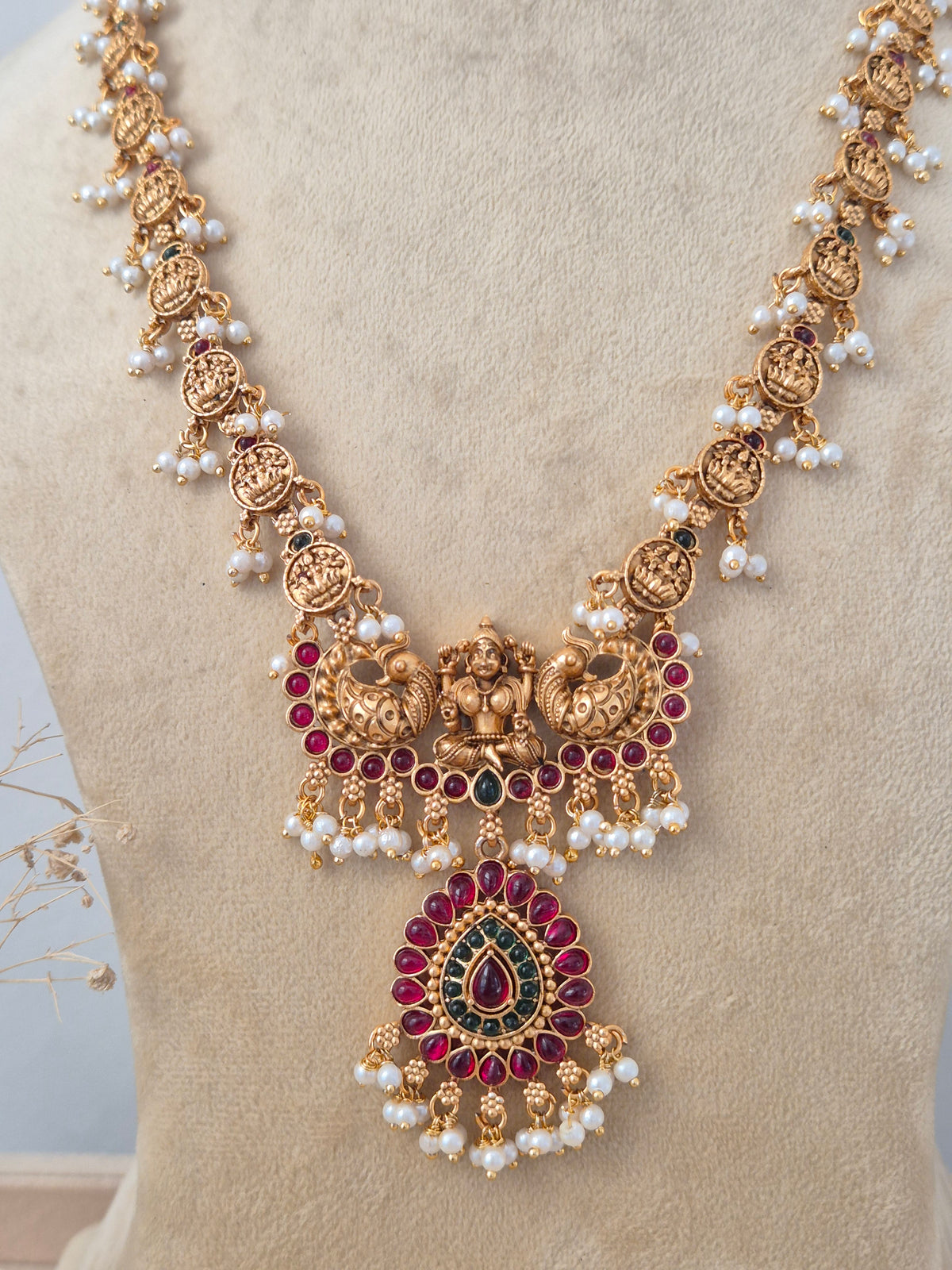 Traditional South Indian Ethnic Long Haram styled against a neutral background, highlighting detailed heritage metalwork, multi-layered golden beads, and classic cascading pearl drops by Naitri.in