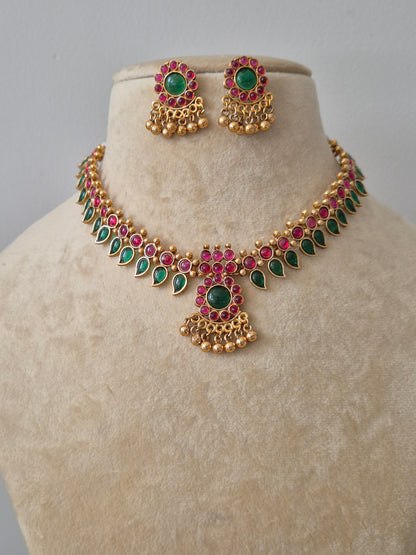 Traditional Indian gold-plated necklace set with green and red stones by naitri.in