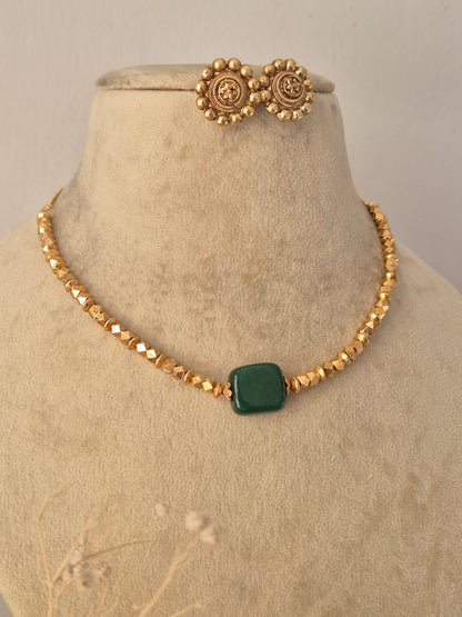 Traditional Indian Minimalist Necklace styled against a neutral background, highlighting the elegant multi-strand golden beads, vibrant green center stone, and sophisticated ethnic craftsmanship by Naitri.in