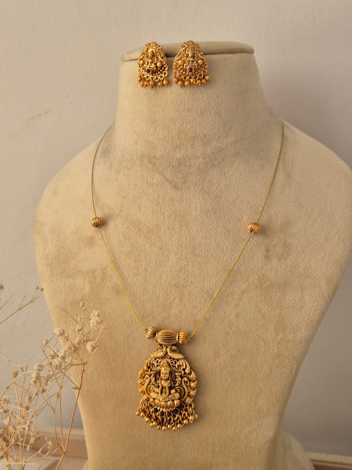 Handcrafted brass alloy traditional Indian necklace set with intricate deity carvings and stone embellishments by Naitri.in