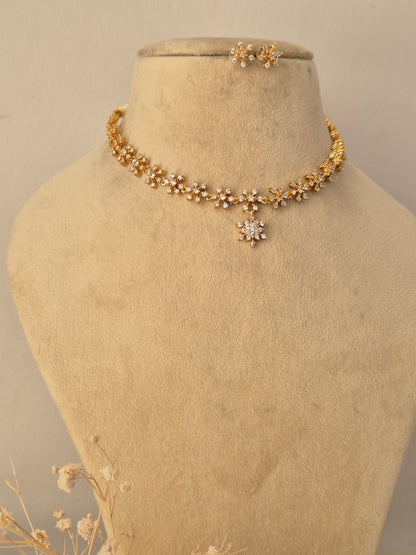 Ornate gold-toned fashion jewelry set with a detailed pendant and matching earrings for ethnic wear by Naitri.in