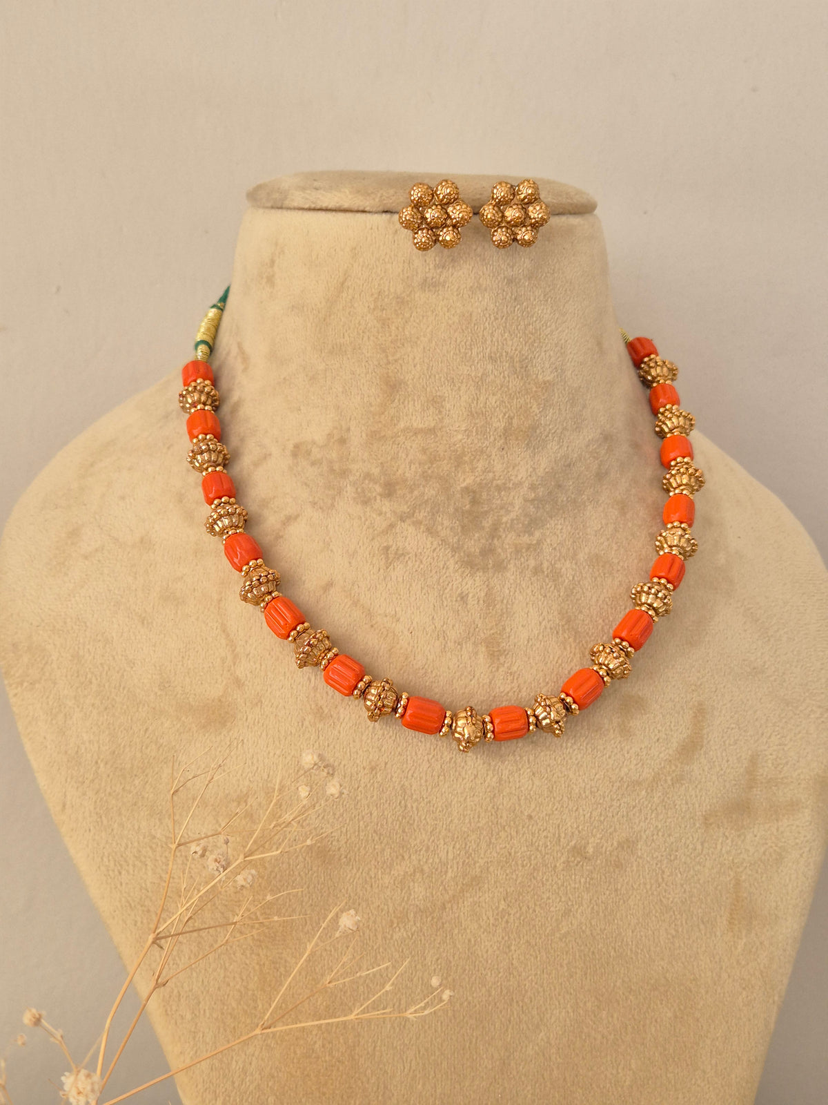 Traditional Indian gold-plated necklace paired with matching floral stud earrings by Naitri.in