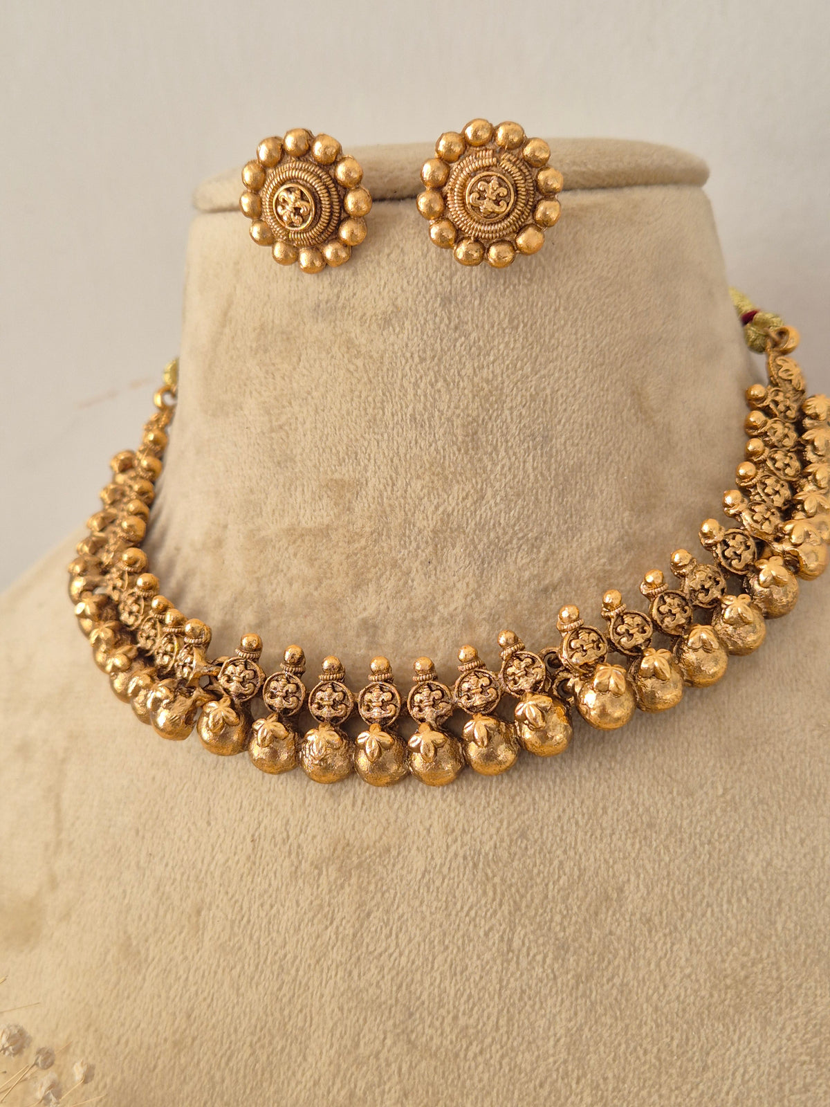 Traditional Indian gold-plated choker necklace featuring intricate temple motifs paired with matching round stud earrings by Naitri
