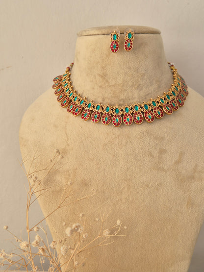 Traditional Indian ethnic gold necklace and earring set with gemstone details. by Naitri.in