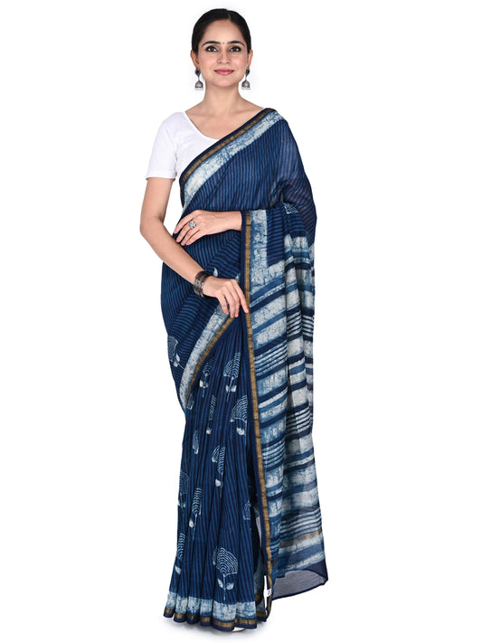 A woman wearing the navy blue Neera cotton-silk saree, featuring vertical white stripes and hand-block printed floral motifs with a thin gold border, paired with a white blouse by naitri.in