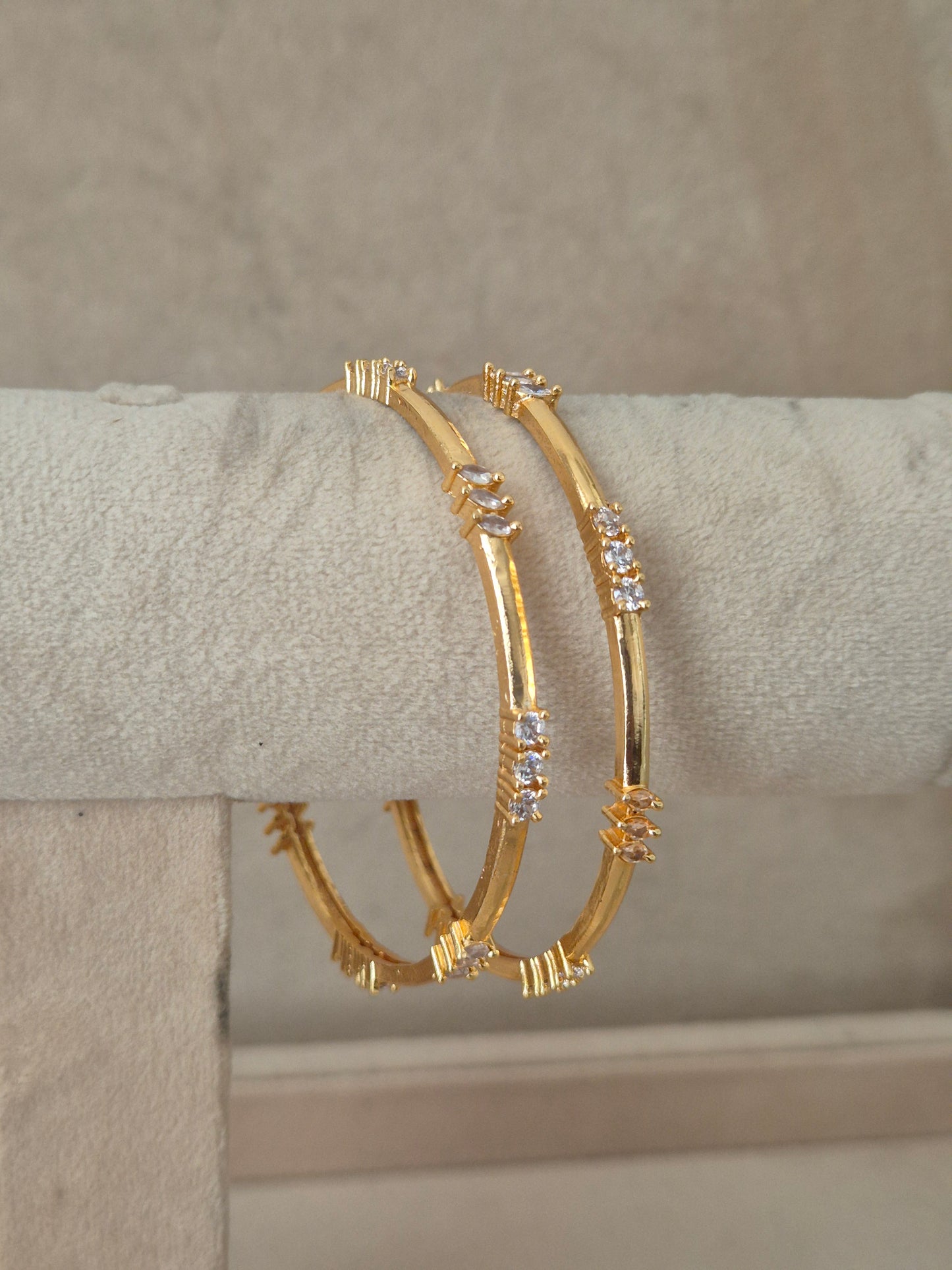 Two gold bangle bracelets with small clear stones, by naitri.in