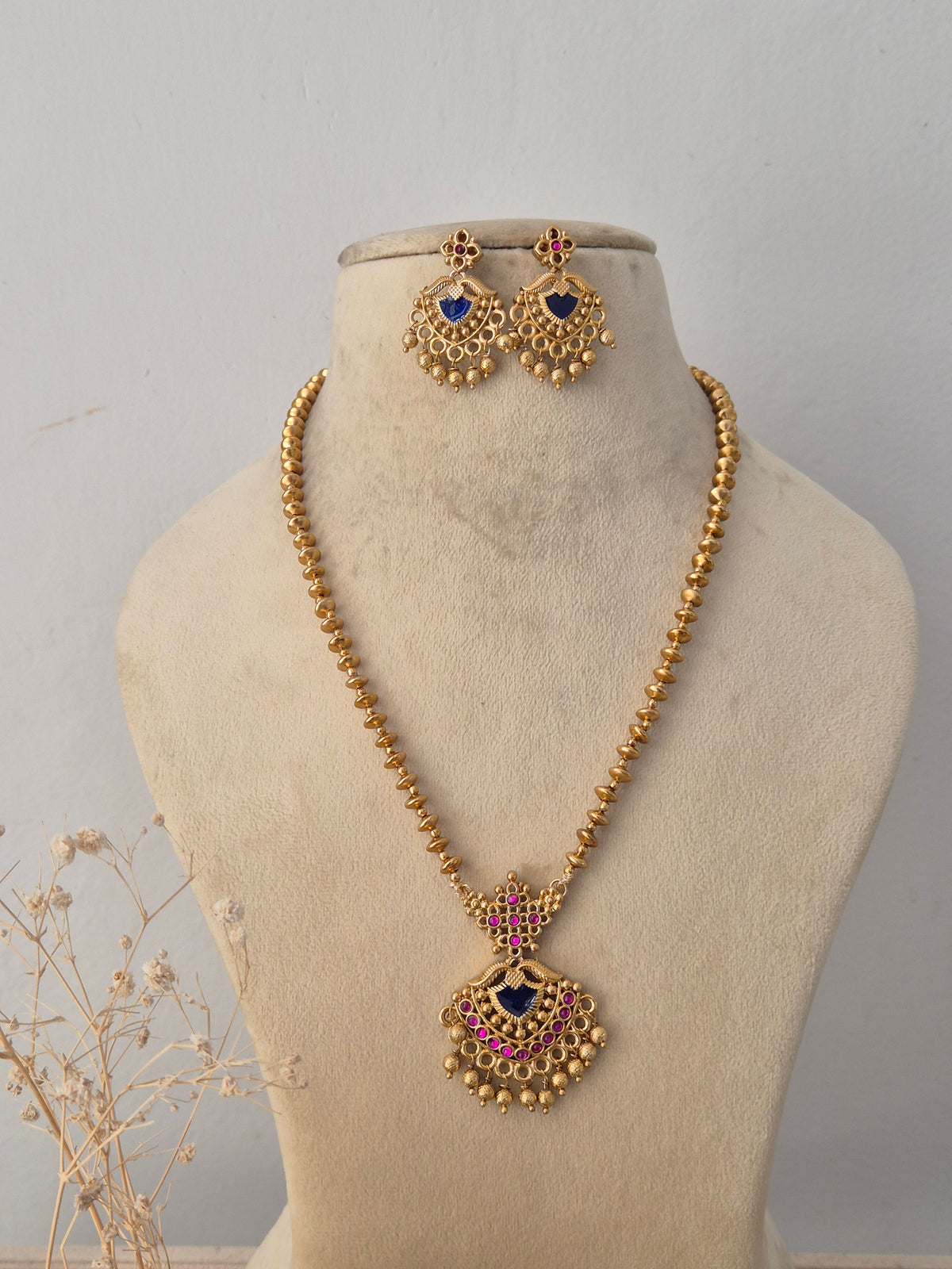  Neetu Necklace Set featuring a traditional gold mangalsutra-style black beaded chain with an intricate temple pendant and matching earrings by Naitri.in
