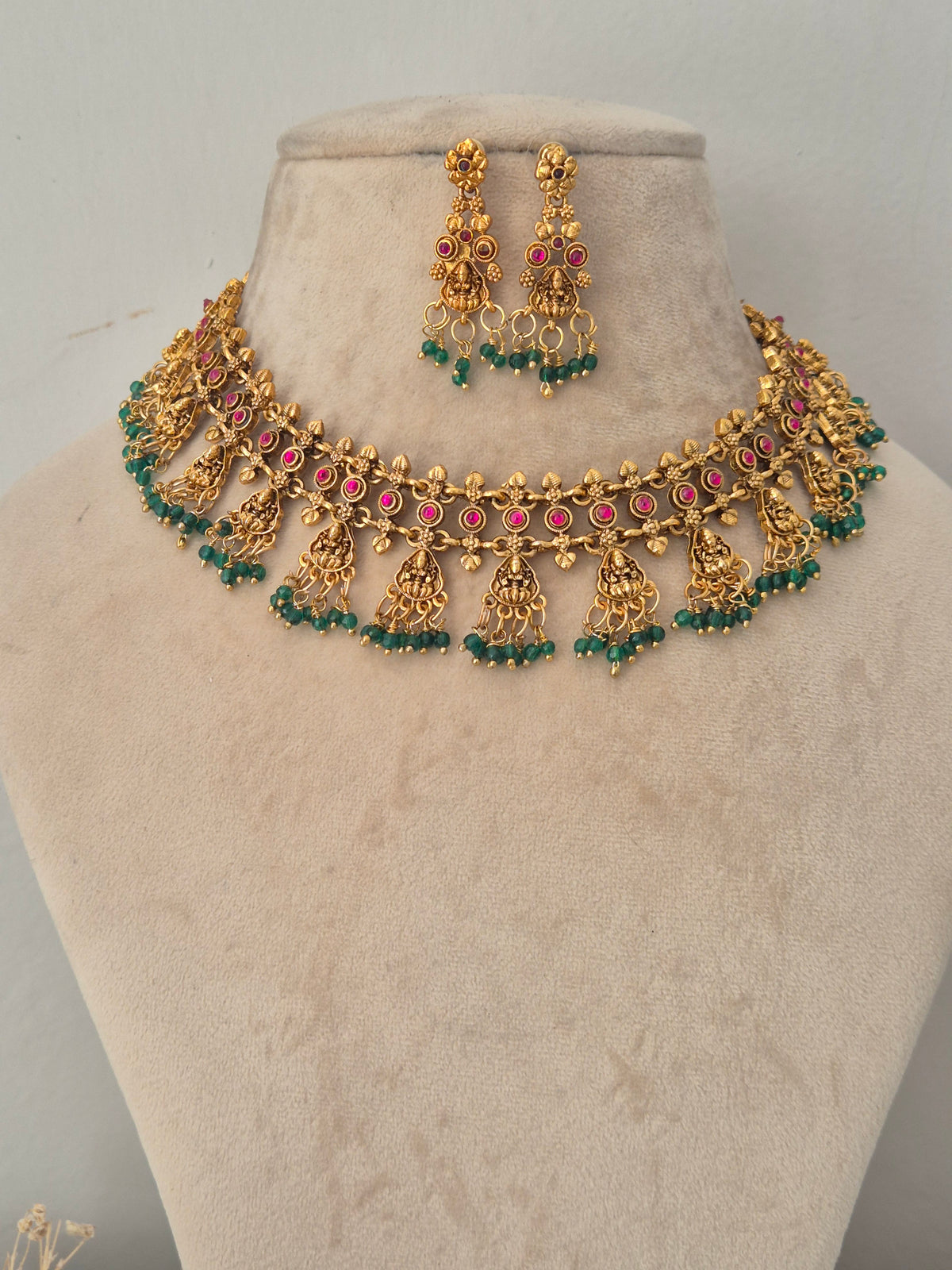 Gold temple choker necklace with pink stones and green bead drops with matching earrings by naitri.in