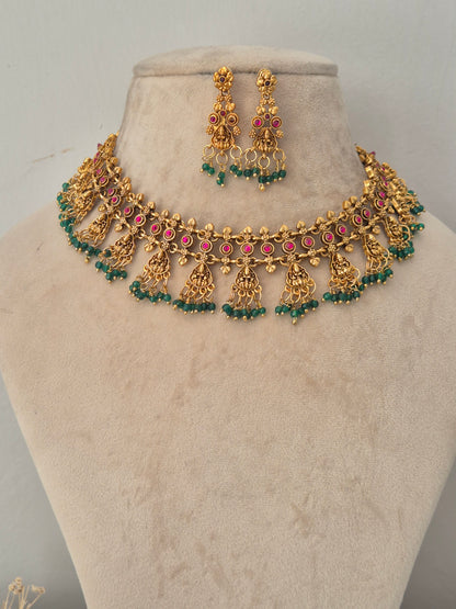 Gold temple choker necklace with pink stones and green bead drops with matching earrings by naitri.in