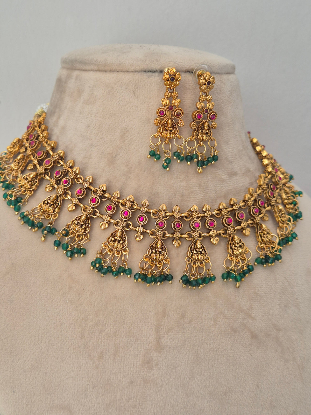 Traditional gold choker necklace and earring set with pink stones and green beads by naitri.in