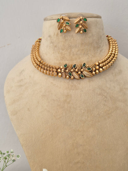 Elegant gold-toned ethnic choker jewelry set with intricate green stone embellishments, by naitri.in