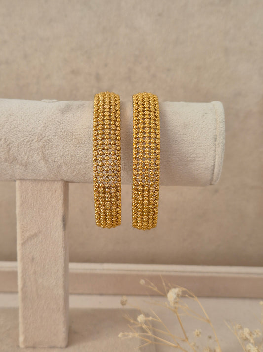 Set of 2 gold-plated bangles featuring a fine beadwork mesh pattern and textured relief finish, by naitri.in