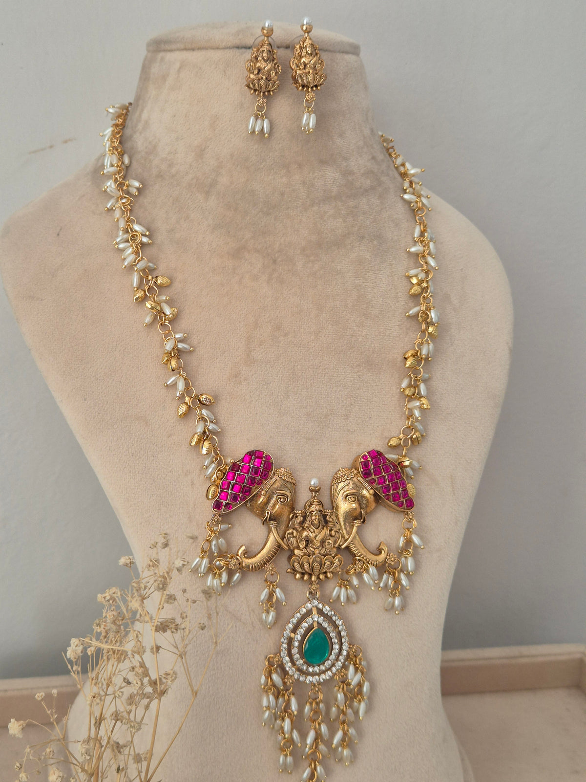 Nonika Necklace Set with Elephant Motif and Green Stone Pendant | Naitri Jewellery, Traditional gold temple necklace with pink and green stones and matching earrings by naitri.in