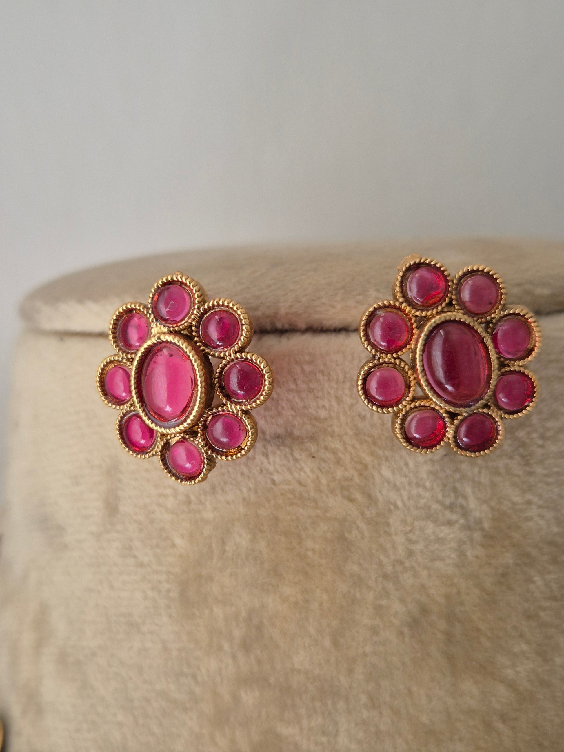 Gold-plated ethnic earring and a central ruby-pink  gemstone flower stud earrings by naitri.in