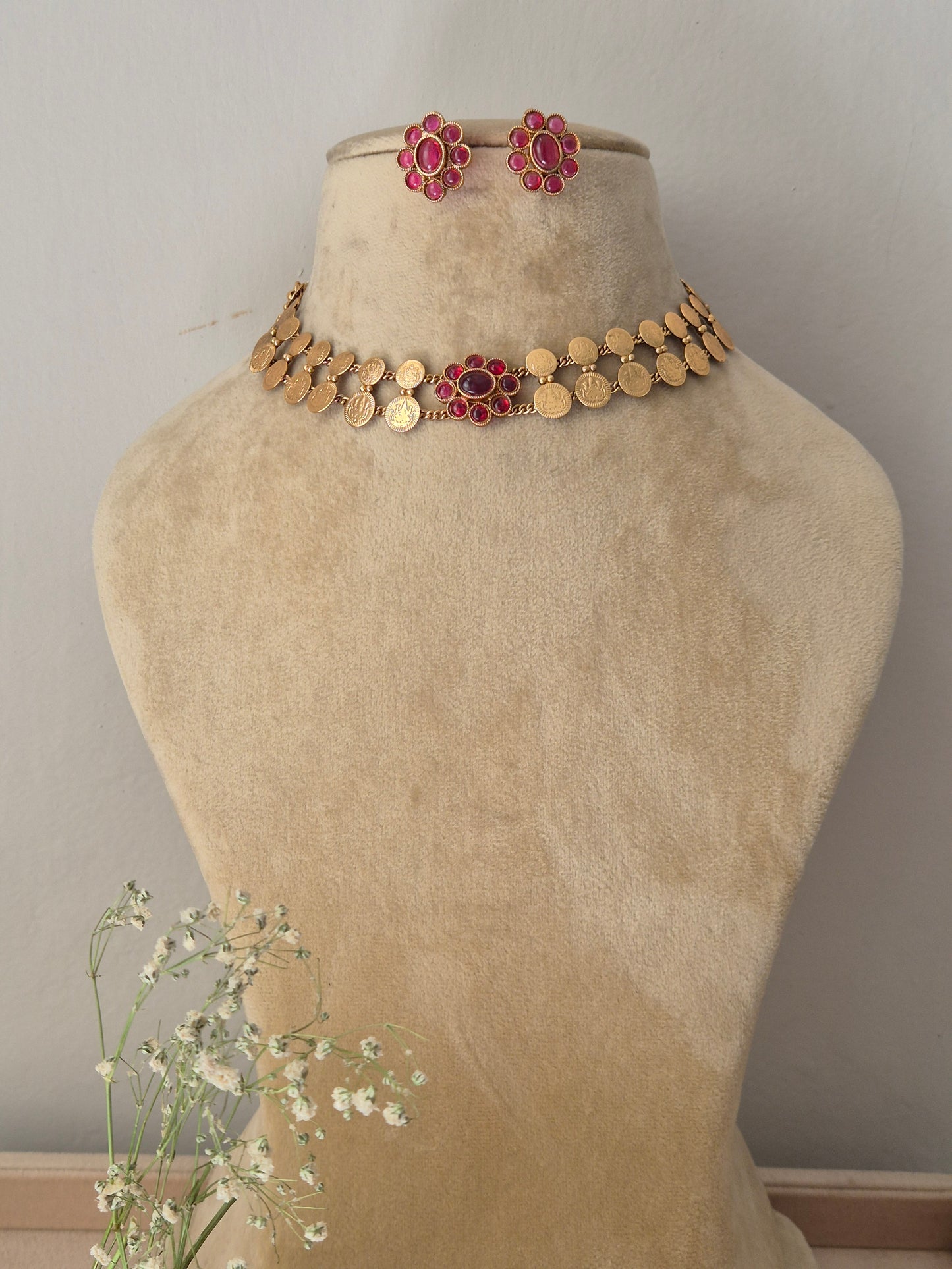 Antique gold choker necklace featuring a central pink stone pendant, with matching earrings by naitri.in
