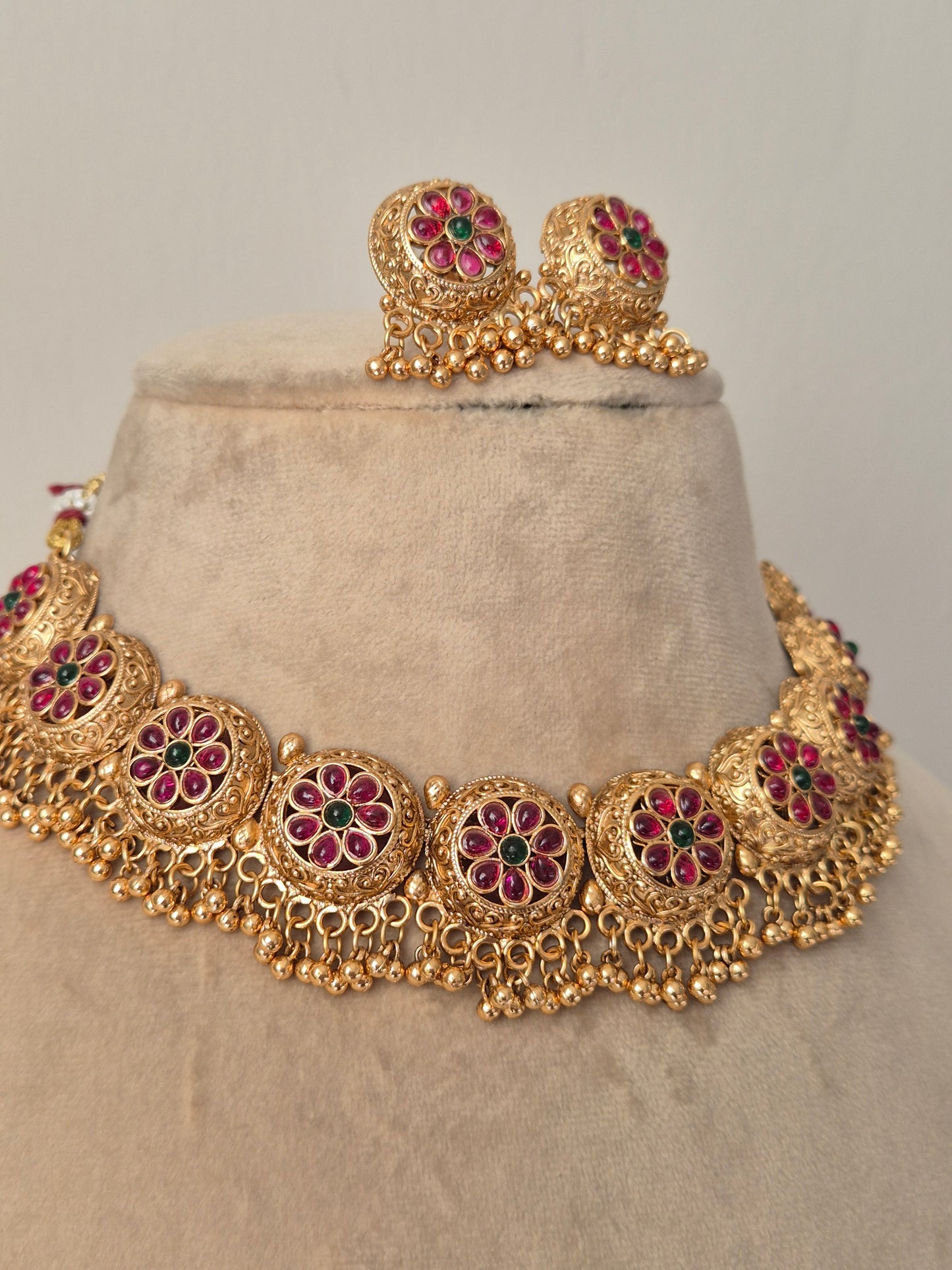 Traditional matte gold necklace set with embossed floral clusters and hanging gold bead drops, featuring intricate leaf engravings 