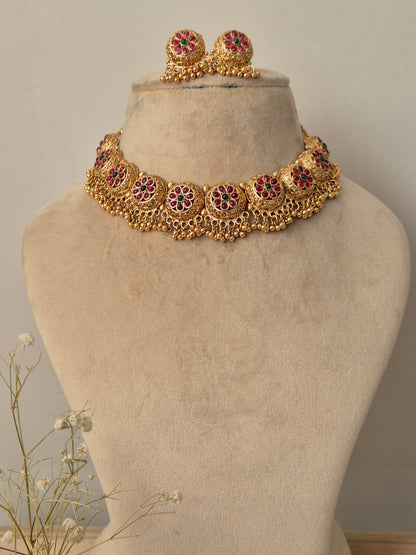 Floral gold necklace adorned with side design like bunches and green red studded flower charms by naitri.in