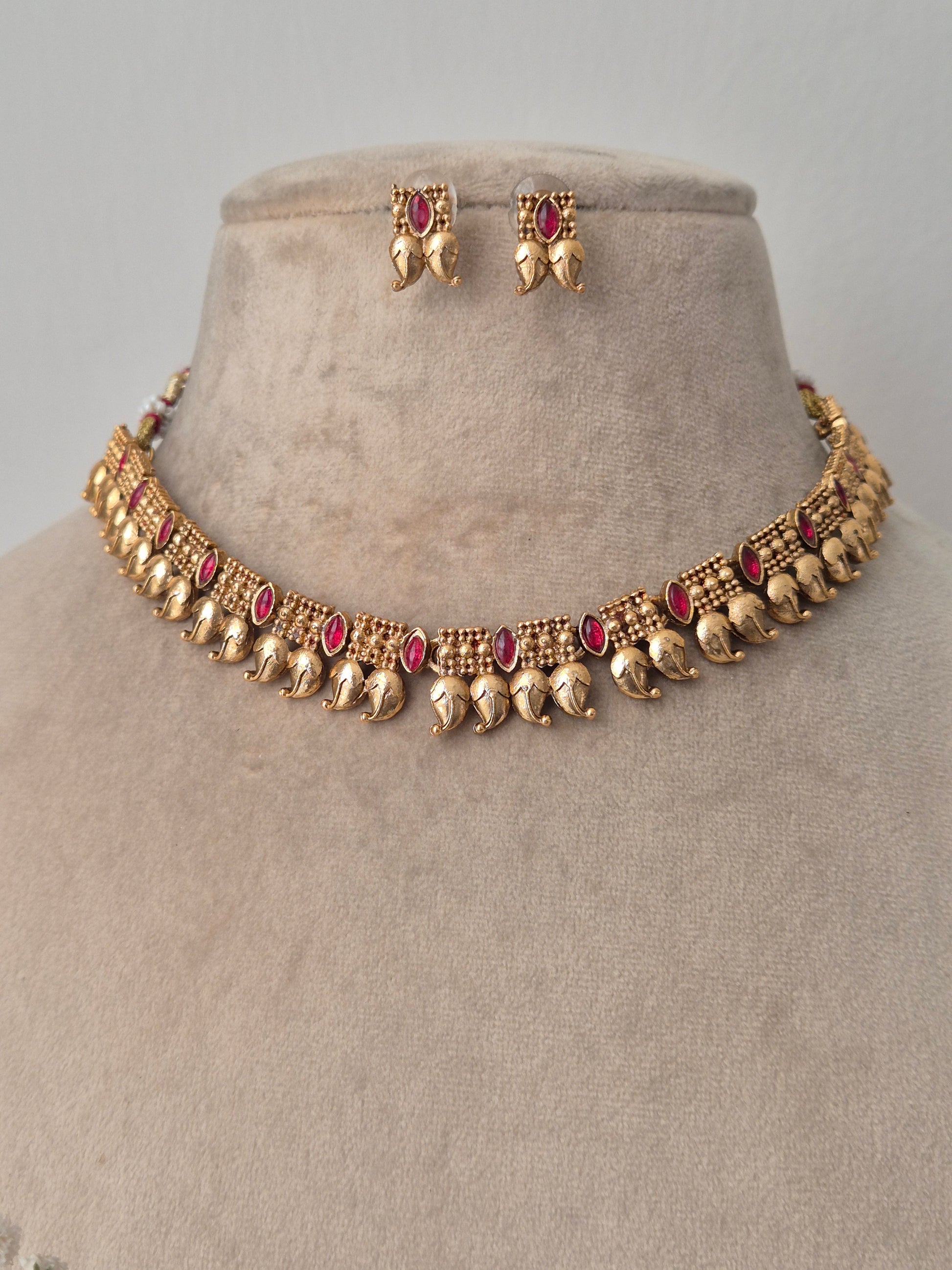 Gold necklace with red gemstones by naitri.in
