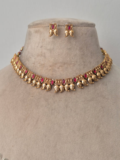 Gold necklace with red gemstones by naitri.in