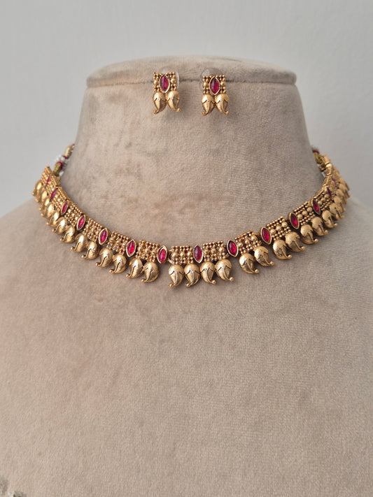 Gold necklace with red gemstones by naitri.in