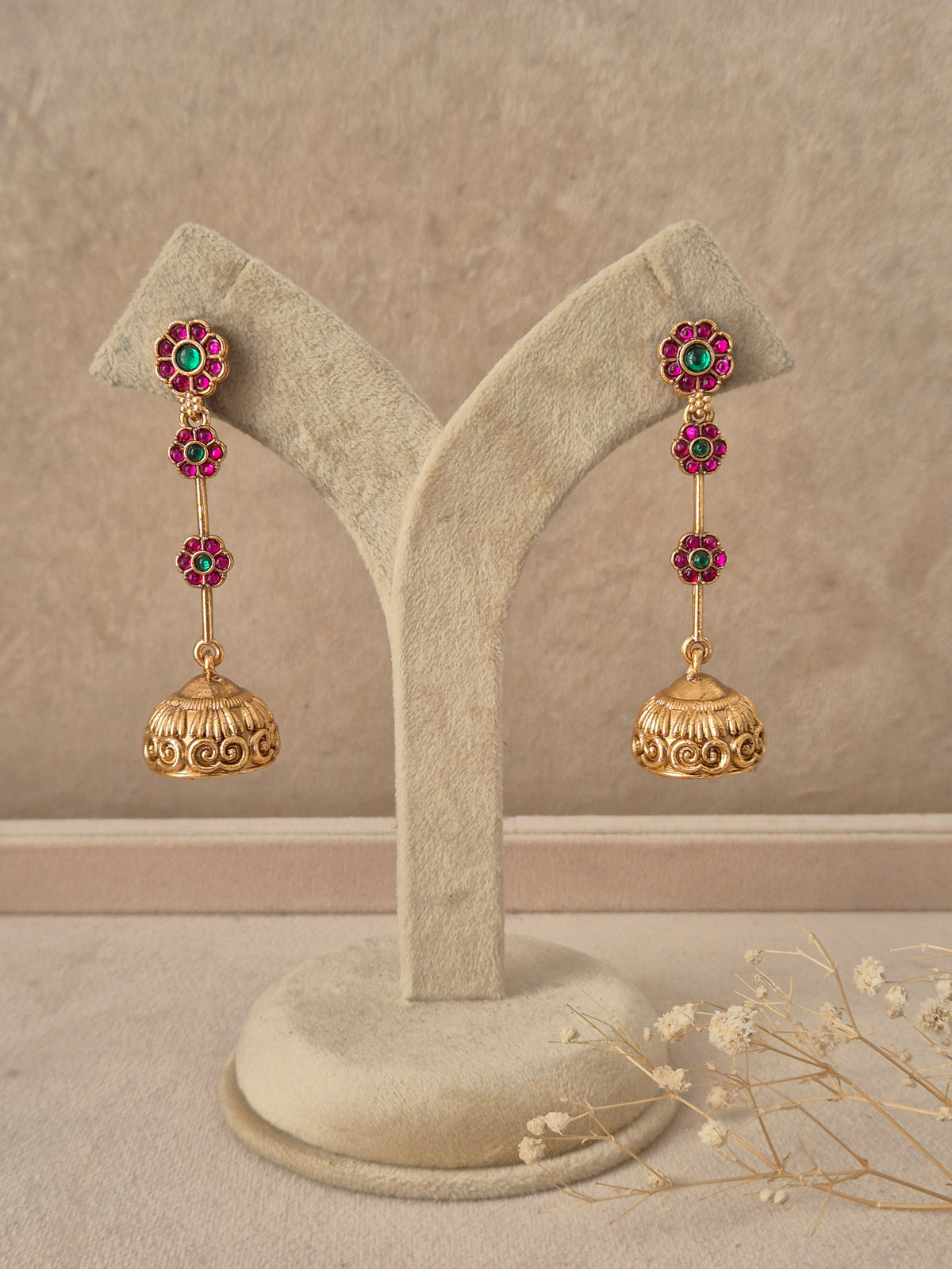 Gold-plated long stone-studded jhumka earrings by naitri.in