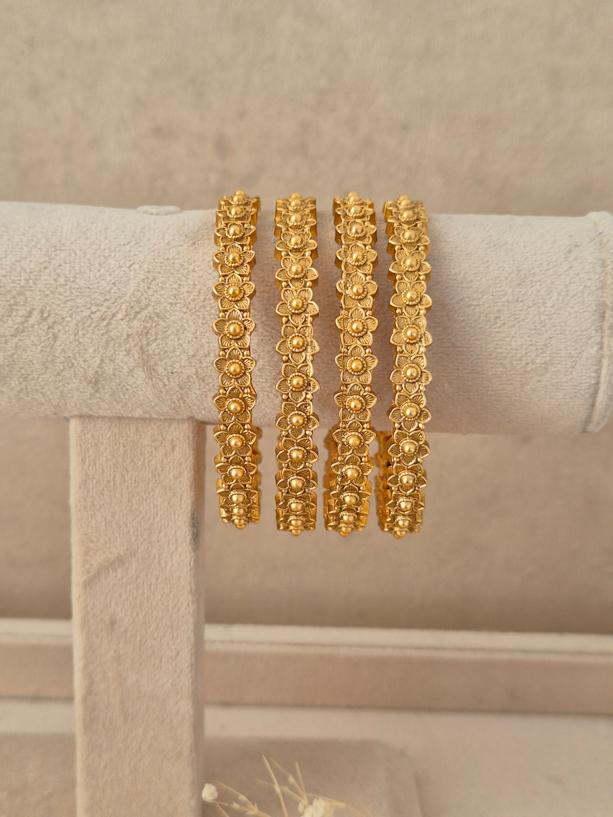  Set of 4 gold-plated Padma bangles featuring a repeated floral motif pattern by naitri.in