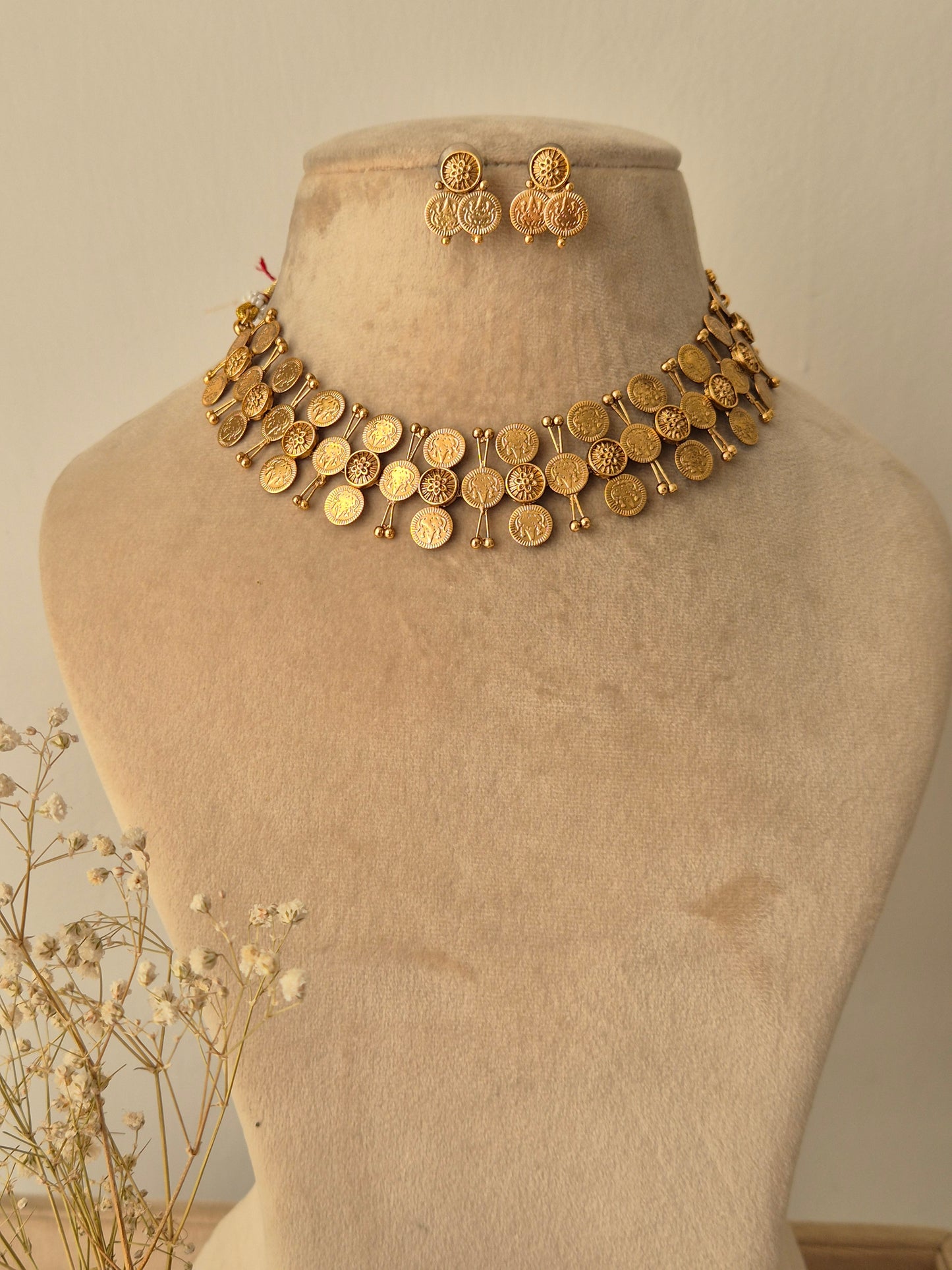 A handcrafted gold-plated choker featuring circular gold coin drops with matching ethnic earrings by naitri.in