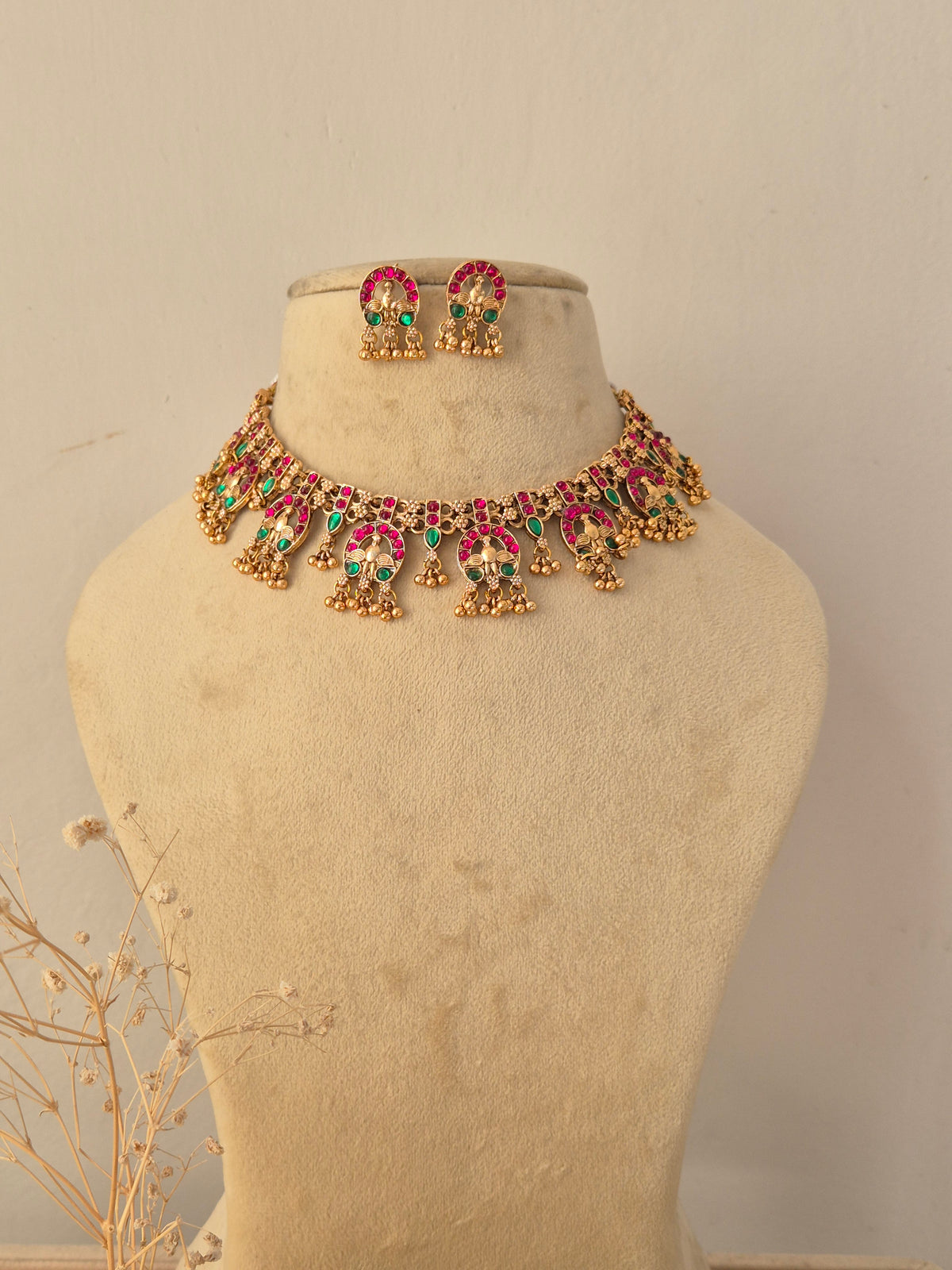 Traditional gold-plated choker necklace set with intricate red and green stone by Naitri.in
