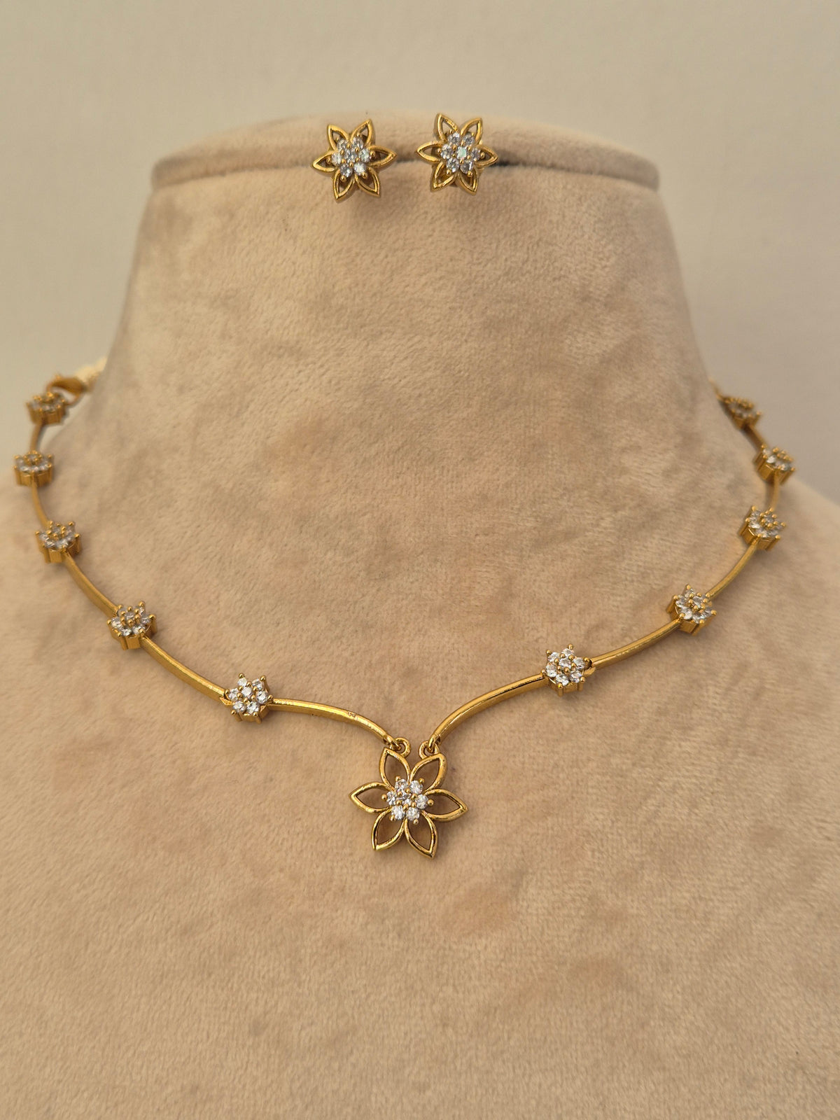 Gold floral pendant necklace with American Diamond accents and matching stud earrings, American Diamond Floral Pendant by naitri.in 