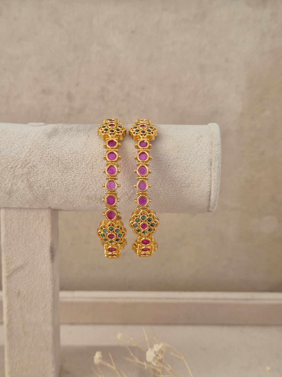 Set of 2 gold-plated bangles studded with ruby red stones, emerald green accents, by naitri.in 