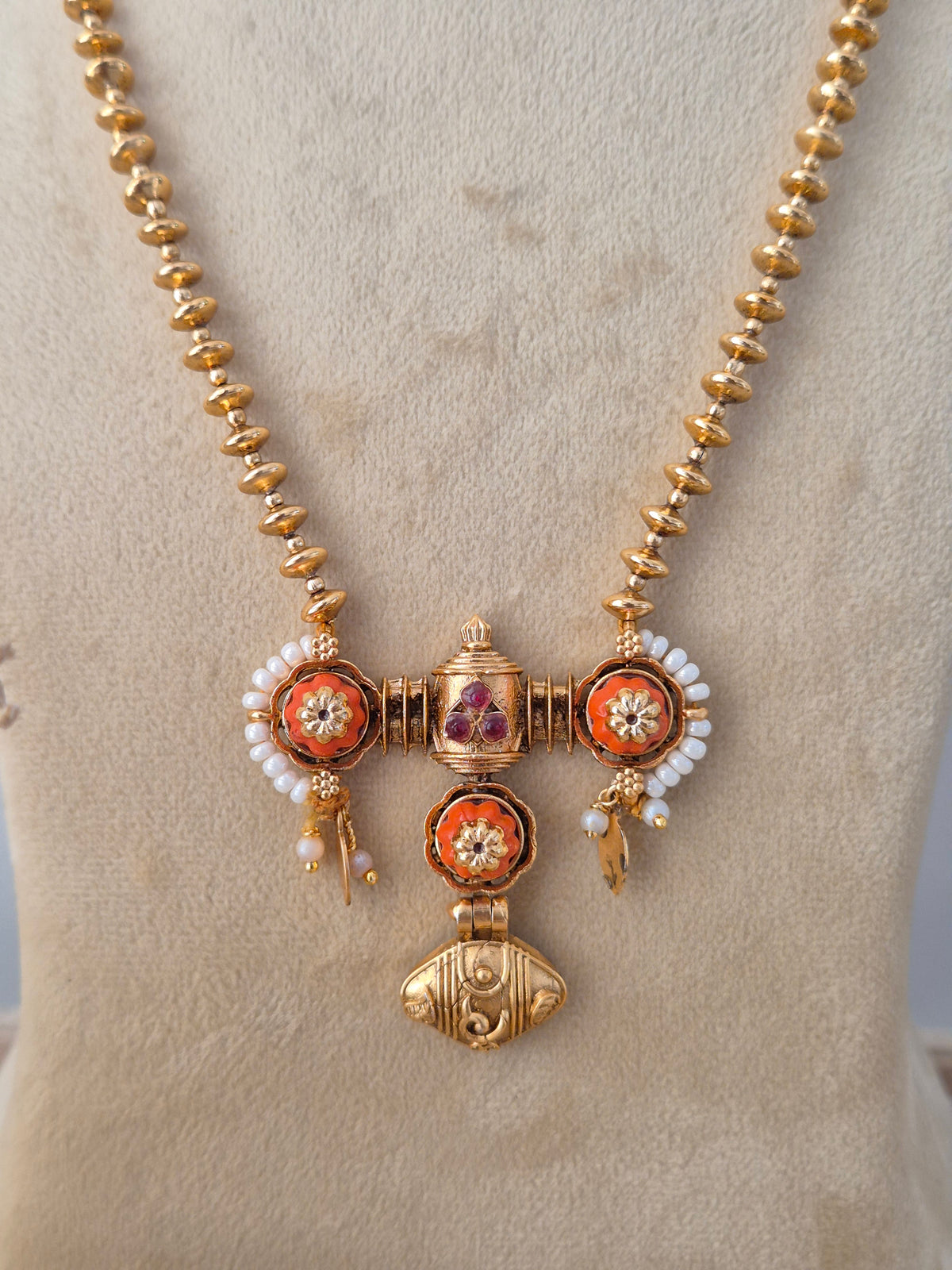 Close-up of the Pavitra traditional Indian necklace featuring fine gold filigree work, vibrant gemstones, and a classic black beaded double-strand chain by Naitri.in