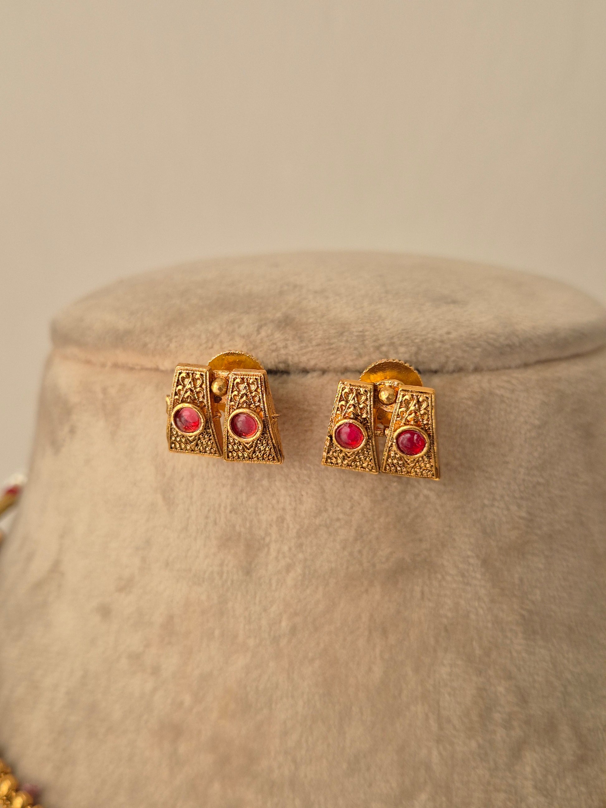 Gold earrings with red gemstones Handcrafted gold-plated brass Antique gold with red-colored stone accents by naitri.in