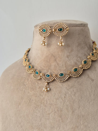 Gold necklace with green stones necklace with same designed earring with green stones by naitri.in