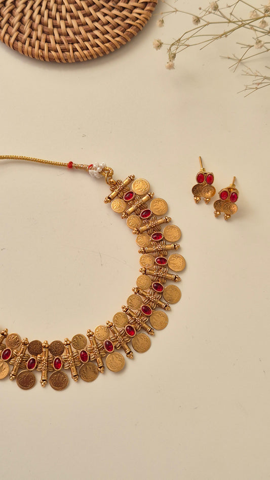 Traditional Indian Pooja necklace set with small red stones, coin-shaped gold charms, and matching jhumka-style earrings by naitri.in